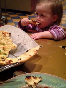 Addie enjoying garlic nan at Bollywood Grill.