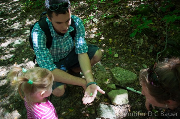 Robby showing Addie a green caterpillar.