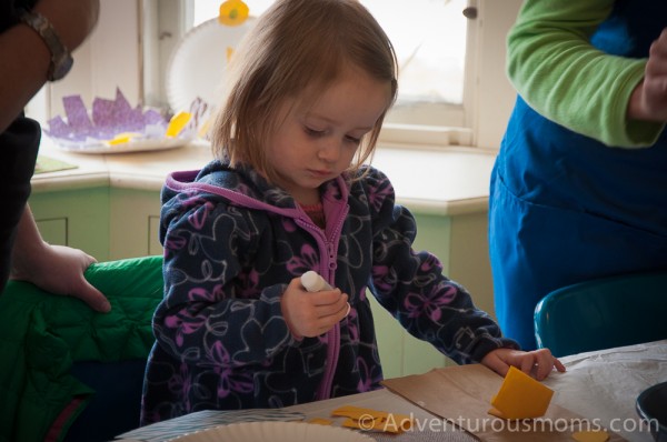 Addie gluing the eyes onto her owl puppet.