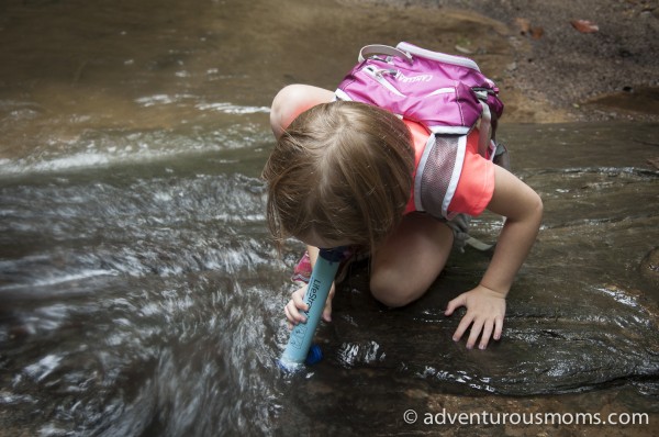 Addie using a  LifeStraw Personal Water Filter