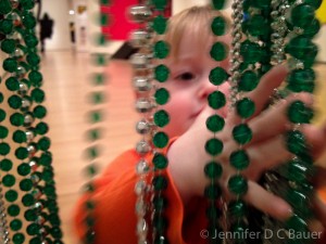 Addison examining the beads hanging in a doorway at the Boston MFA.